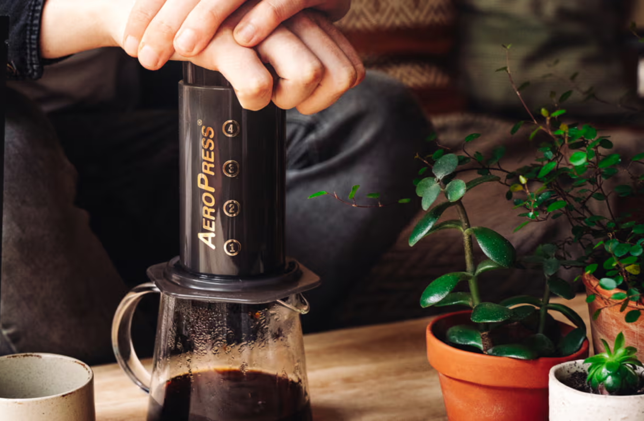 A picture of a hand pressing coffee in an aeropress